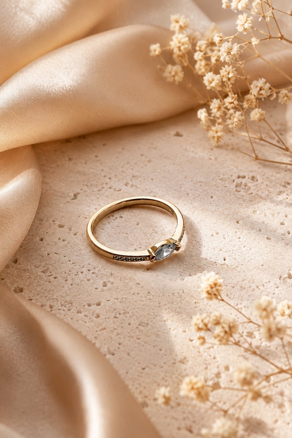 18k apzeltīts smalks gredzens ar marķīzes formas cirkoniju uz gaiša luksusa fona