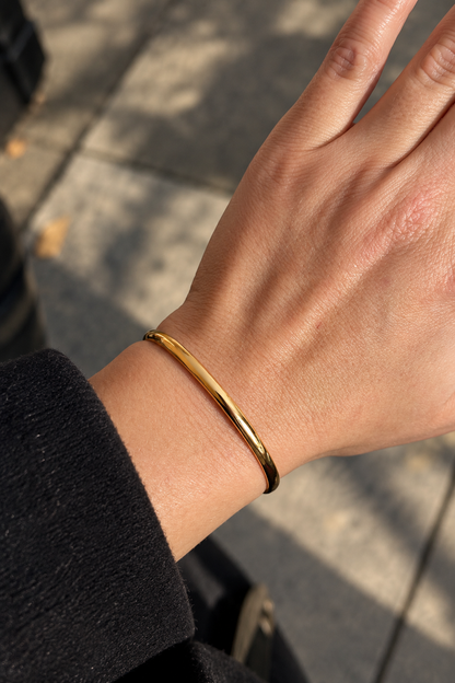 Apzeltīta bangle rokassprādze siltā saules gaismā